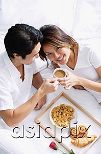 AsiaPix - Couple on bed, breakfast tray between them, woman looking at camera