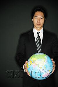 AsiaPix - Businessman standing, holding globe in two hands