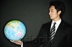 AsiaPix - Businessman holding globe in one hand