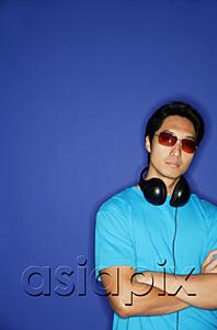 AsiaPix - Man with sunglasses, headphones around his neck, arms crossed