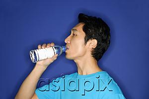 AsiaPix - Man drinking water from disposable bottle