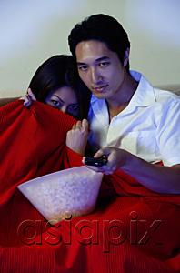 AsiaPix - Couple watching TV, woman hiding under blanket