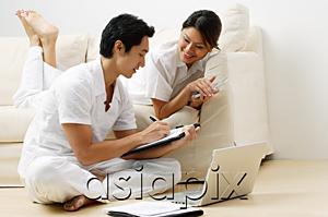 AsiaPix - Couple at home in living room, doing home finances