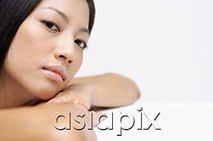 AsiaPix - Woman resting head on arms, looking at camera, side view