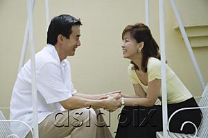 AsiaPix - Couple sitting on swing, looking at each other