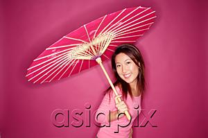 AsiaPix - Woman with umbrella, standing against pink background