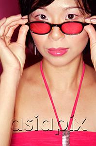 AsiaPix - Woman adjusting sunglasses, looking at camera