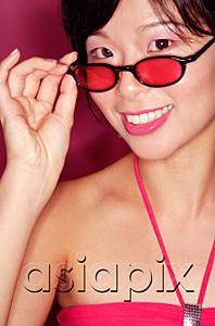 AsiaPix - Woman adjusting sunglasses, smiling at camera