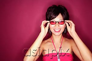 AsiaPix - Woman adjusting sunglasses, smiling at camera