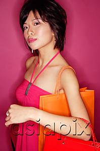 AsiaPix - Young woman carrying shopping bags, looking at camera
