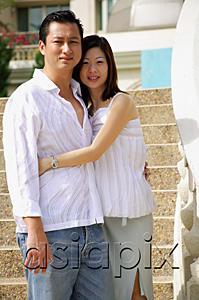 AsiaPix - Couple standing, embracing, looking at camera