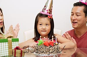 AsiaPix - Girl with birthday cake, parents on either side clapping