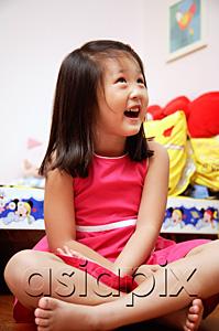 AsiaPix - Young girl sitting cross-legged, looking away, smiling