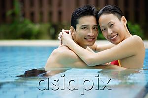 AsiaPix - Couple in swimming pool, embracing, smiling at camera
