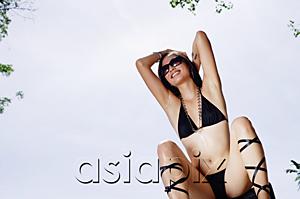 AsiaPix - Woman in bikini, sitting, hands behind head, smiling