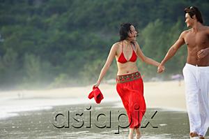 AsiaPix - Couple running along beach, ankle deep in water, holding hands
