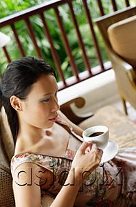 AsiaPix - Woman sitting, holding cup and saucer