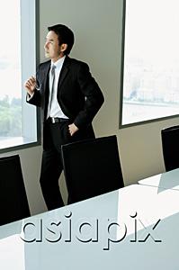 AsiaPix - Businessman standing next to window in conference room