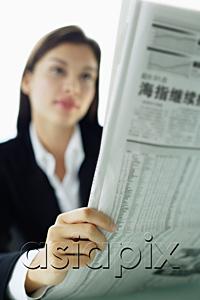AsiaPix - Businesswoman reading newspaper, selective focus