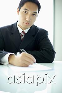 AsiaPix - Businessman with pen and paper, looking at camera