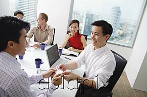 AsiaPix - Executives around conference table, two businessmen exchanging business cards