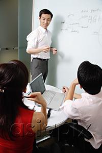 AsiaPix - Executives in meeting room, male executive standing next to whiteboard