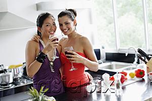 AsiaPix - Two women in kitchen, drinks in hand, smiling at camera