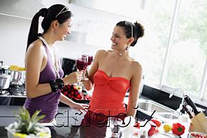 AsiaPix - Two women in kitchen, drinks in hand, toasting