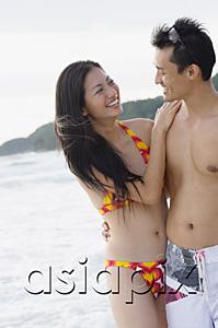 AsiaPix - Couple on beach, standing side by side, looking at each other, womans hand on mans shoulder