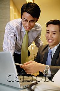 AsiaPix - Businessmen working together, looking at laptop