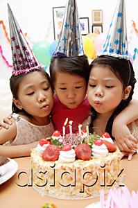 AsiaPix - Three girls blowing candles on birthday cake