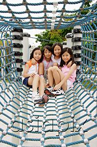 AsiaPix - Four girls at playground, sitting in net tunnel