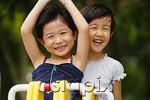 AsiaPix - Two girls on a seesaw, smiling