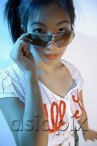 AsiaPix - Young woman adjusting sunglasses, looking at camera