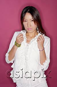 AsiaPix - Young woman in white outfit, hands in fists, looking at camera