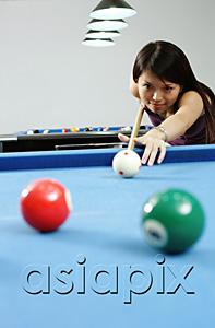 AsiaPix - Woman holding pool cue, aiming at ball