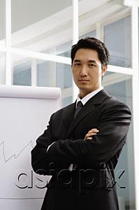 AsiaPix - Businessman standing next to flipchart, arms crossed