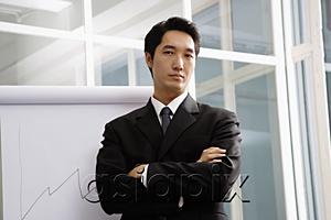AsiaPix - Businessman standing next to flipchart, looking at camera