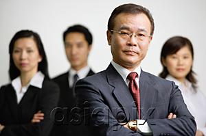 AsiaPix - Businessman with arms crossed, people in the  background