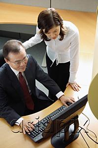 AsiaPix - Two business people looking at computer