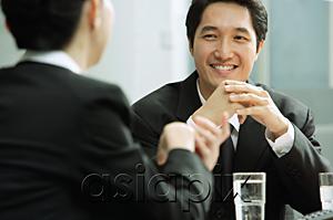 AsiaPix - Businessman smiling, at woman in front of him