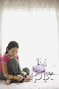 AsiaPix - Girl sitting on bed, painting toenails