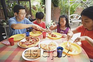 AsiaPix - Family of four having pizza on patio