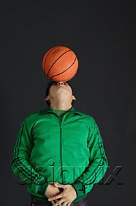 AsiaPix - Young man in green jacket balancing basketball on nose