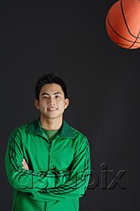 AsiaPix - Young man in green jacket, arms crossed, basketball in the air