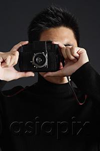 AsiaPix - Young man dressed in black looking through camera
