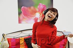 AsiaPix - Girl in bedroom, listening to headphone, smiling