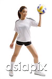 AsiaPix - Young woman standing, holding volleyball in one hand