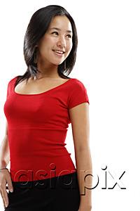 AsiaPix - Young woman standing and smiling, looking away