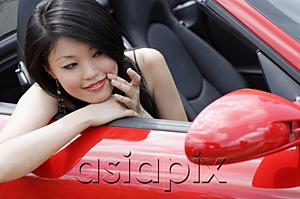 AsiaPix - Woman sitting in convertible, looking at herself in side view mirror